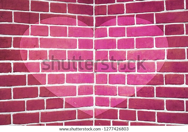 Symmetric drawn heart on pink brick wall close-up.
Background with painted heart. Interior with love symbol decor.
Valentine day image on wall. Brickwork with exterior picture. Angle
of brick wall.