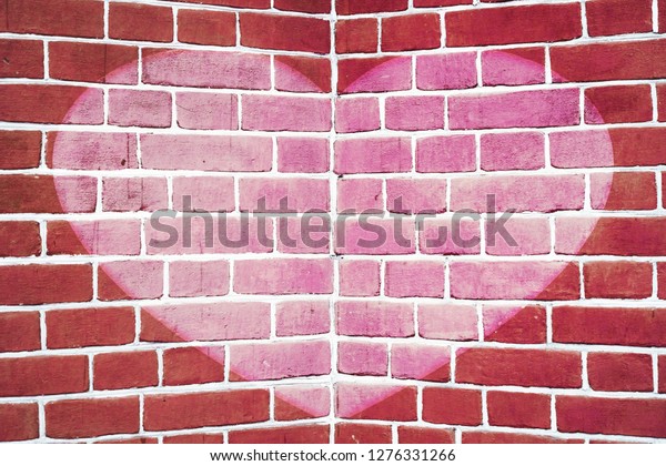 Symmetric pink drawn heart on red brick wall\
close-up. Background with painted heart. Interior with love symbol\
decor. Valentine day image on wall. Brickwork with exterior\
picture. Angle of brick\
wall