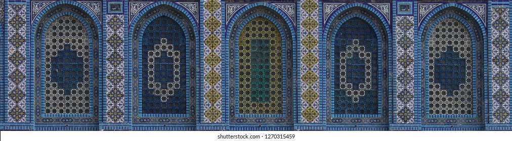 Symmetric raw of colorful tiled windows with floral and geometric arabesque patterns of the exterior facade of the Dome of the Rock Islamic Shrine on the Temple Mount in the Old City of Jerusalem