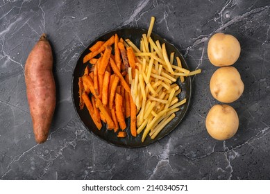 Symmetrical mix of sweet potato fries, French fries and raw vegetables on a dark background, top view - Powered by Shutterstock