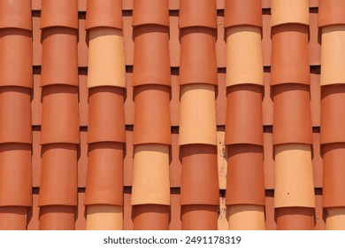 Symmetrical pattern of terracotta roof tiles with varying shades in close-up in the Sun. sstkBackgrounds - Powered by Shutterstock