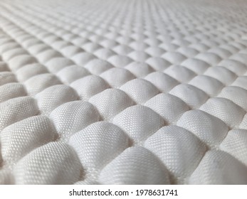 Symmetrical and repetitive design and shape of white in colour bedding cover.