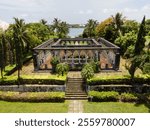 Symmetrical terraced garden on Paradise Islands, featuring manicured hedges, stone pathways, fountains and tropical trees 