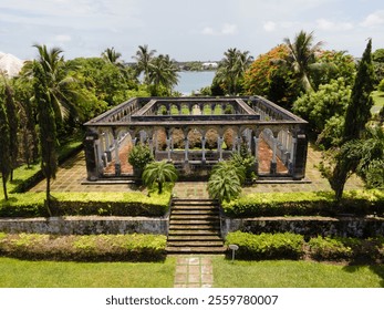 Symmetrical terraced garden on Paradise Islands, featuring manicured hedges, stone pathways, fountains and tropical trees  - Powered by Shutterstock