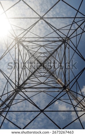 Symmetrical tower structure viewed from below, forming repetitive triangles.