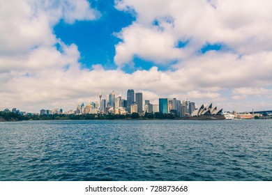 Symmetrical View From A Ferry On Sydney City With Clouds Above. 