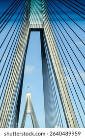 Symmetrical view of a modern cable-stayed bridge with strong architectural lines and light traffic. Urban scene with engineering focus, shot from a moving vehicle. Ideal for concepts like infrastructu