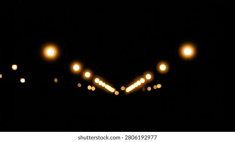 Symmetrical V-shape composition of glowing, out-of-focus golden lights creating a beautiful bokeh effect on a deep black background. Mysterious and elegant atmosphere with ample copy space for text or design elements. Perfect for overlays and banners