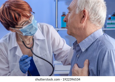 A sympathetic female doctor with stethoscope in a white coat and a senior male patient with his hand on his chest and complaining of a heart attack. Professional medical care in the hospital. - Shutterstock ID 1922396534