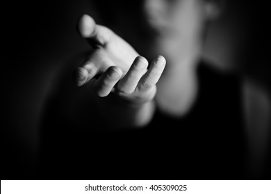 Sympathetic Single Human Hand Reaching Out From Out Of Focus Person In Black And White