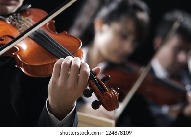 Symphony music, violinist at concert, hand close up