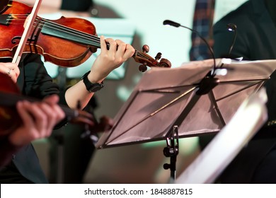 Symphony Music. Woman Playing The Violin In Orchestra Near Music Note Stand