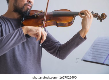 Symphony Orchestra On White Background, Hands Playing Violin. Male Violinist Playing Classical Music On Violin. Talented Violinist And Classical Music Player Solo Performance.