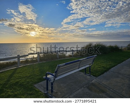 A Symphony of Serenity Captured in the Stillness of an Empty Park Bench Overlooking the Vast and Timeless Majesty of the Open Sea.