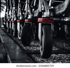 Symphony of Wheels: A captivating composition capturing a row of shopping cart wheels aligned in perfect harmony. The contrast of sleek gray and vibrant red hues creates a visually engaging pattern, l - Powered by Shutterstock