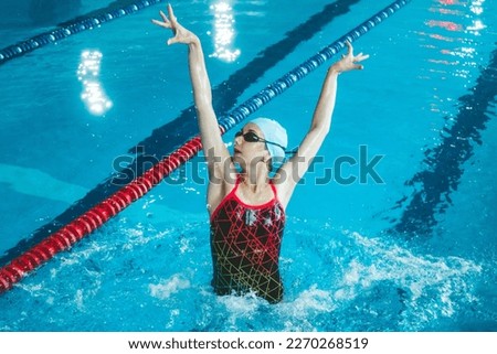 Synchronized girl working out tricks in the pool. Synchronized swimming, sports in the water. Professional sportswoman doing exercises in the pool. Training before the competition