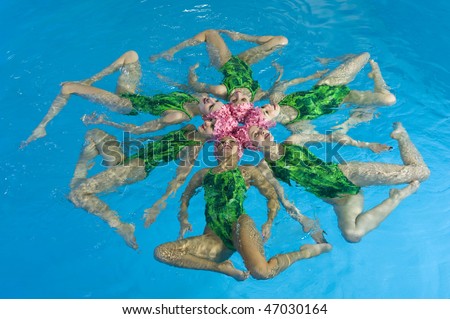 Synchronized swimmers hold pose for camera