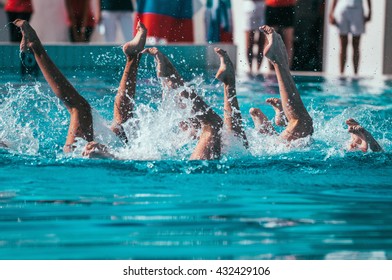 Synchronized swimmers performance with legs outside water - Powered by Shutterstock