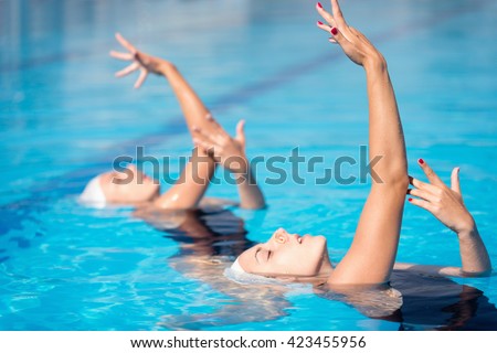 Synchronized swimming duet performing in swimming pool