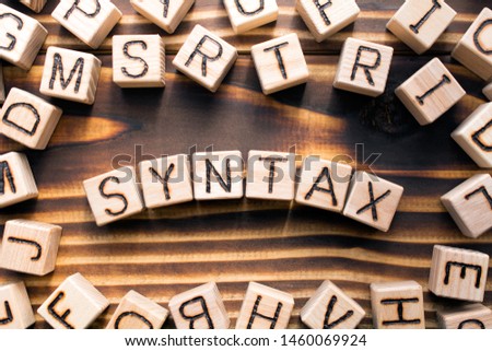 syntax  composed of wooden cubes with letters, grammatical arrangement of words in a sentence concept, the random letters around, top view on wooden background