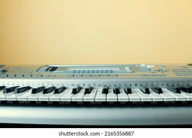 Synthesizer keys close-up, selective focus, front view, synthesizer on a yellow wall background