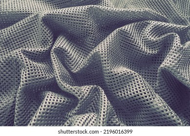 Synthetic fabric with holes laid in waves. Beautiful drape. Fabric for curtains, interior design, and decor. Wrinkled gray fabric. - Shutterstock ID 2196016399