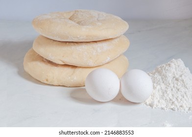 Syrian Bread On The Table With Eggs And Flour Around