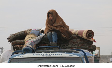 A Syrian refugee child in a rainy weather, a child sits on the roof of a car while fleeing the bombing of Idlib.
Aleppo, Syria 17 April 2018