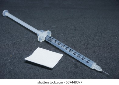 Syringe And Alcohol Swab On The Black Table