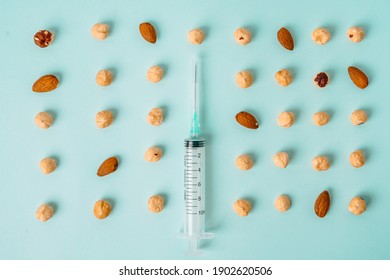 A Syringe Among A Handful Of Almonds And Hazelnuts. The Concept Of Nut Allergy And Allergen Control