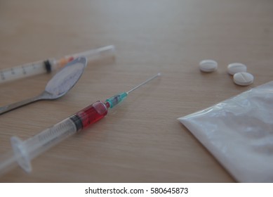syringe and blood, Drug and  spoon cooked heroin on a wooden background. in the studio. - Shutterstock ID 580645873