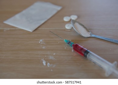 syringe and blood, Drug and  spoon cooked heroin on a wooden background. in the studio. - Shutterstock ID 587517941