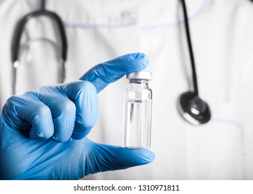 A syringe and a bottle with an injection solution.The doctor is holding a vial with vaccination. Liquid medication or drug.