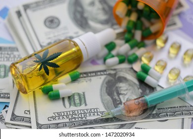 Syringe Bottle Of Marijuana Pills Lie Against Backdrop Of Cash Dollars. Illegal Drug Trafficking Concept