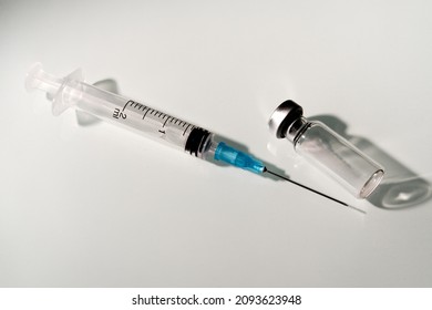 Syringe And Empty Vaccine Vial On Light Background. Close-up. Copyspace