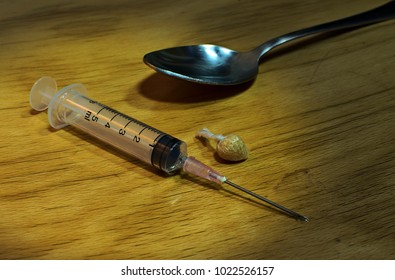 Syringe with heroin and spoon, addiction concept, dangerous habit - Shutterstock ID 1022526157