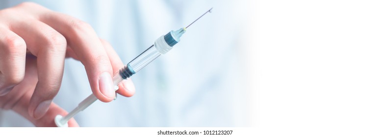 Syringe, medical injection in hand, palm or fingers. Medicine plastic vaccination equipment with needle. Nurse or doctor. Liquid drug or narcotic. Health care in hospital.