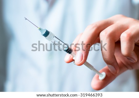 Syringe, medical injection in hand, palm or fingers. Medicine plastic vaccination equipment with needle. Nurse or doctor. Liquid drug or narcotic. Health care in hospital.