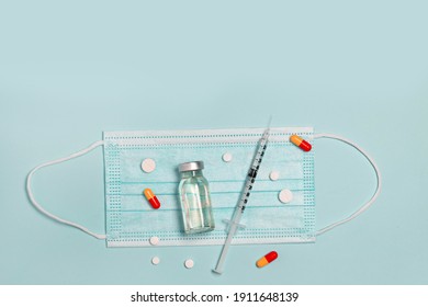 Syringe with medicine from glass vial , medical mask and color pills on blue background, flat lay, copyspace. Vaccination against influenza, covid 19, measles, coronavirus disease. Vaccination   - Powered by Shutterstock