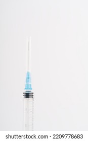 A Syringe On A White Background. Closeup. Vertical Snapshot. Space For Text