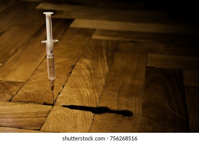 Syringe on the wooden floor. Dark theme. - Shutterstock ID 756268516