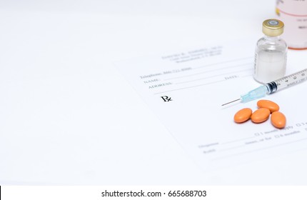 A Syringe And Pills On Top Of A Prescription Pad White Background