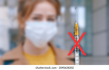 A Syringe With A Red Denial Symbol In Front Of Blurry Woman. A Syringe Containing The Covid Vaccine. Covid-19 Anti Vax. Vaccine Hesitancy. No-Vax Movement. Corona Virus Vaccination.