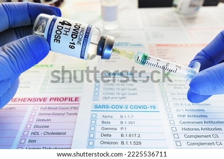 Syringe and vial of coronavirus vaccine labeled with the fourth dose on the label for vaccination of patients. hands of a doctor dosing into the syringe dose of the fourth dose of the COVID-19 vaccine