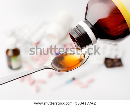 Syrup from bottle in spoon pouring