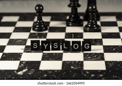 Syslog short for System Logging Protocol represented by black and white letter tiles on a marble chessboard with chess pieces