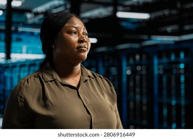 System admin walking in computing facility with server hardware supporting business needs, while doing checkup, ensuring equipment works at optimum operational performance for smooth operations.