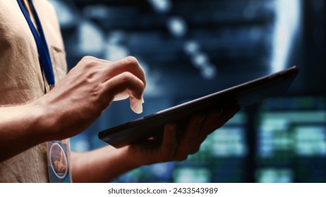 System administrator checking energy efficient supercomputers using renewable sources to minimize consumption and reduce business carbon footprint. Expert working in sustainable data center, close up