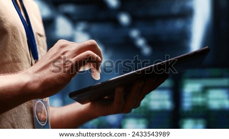 System administrator checking energy efficient supercomputers using renewable sources to minimize consumption and reduce business carbon footprint. Expert working in sustainable data center, close up