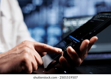 System administrator coding in data center using javascript language, close up. Competent manager updating software on server rigs on tablet terminal, ensuring optimal performance and security